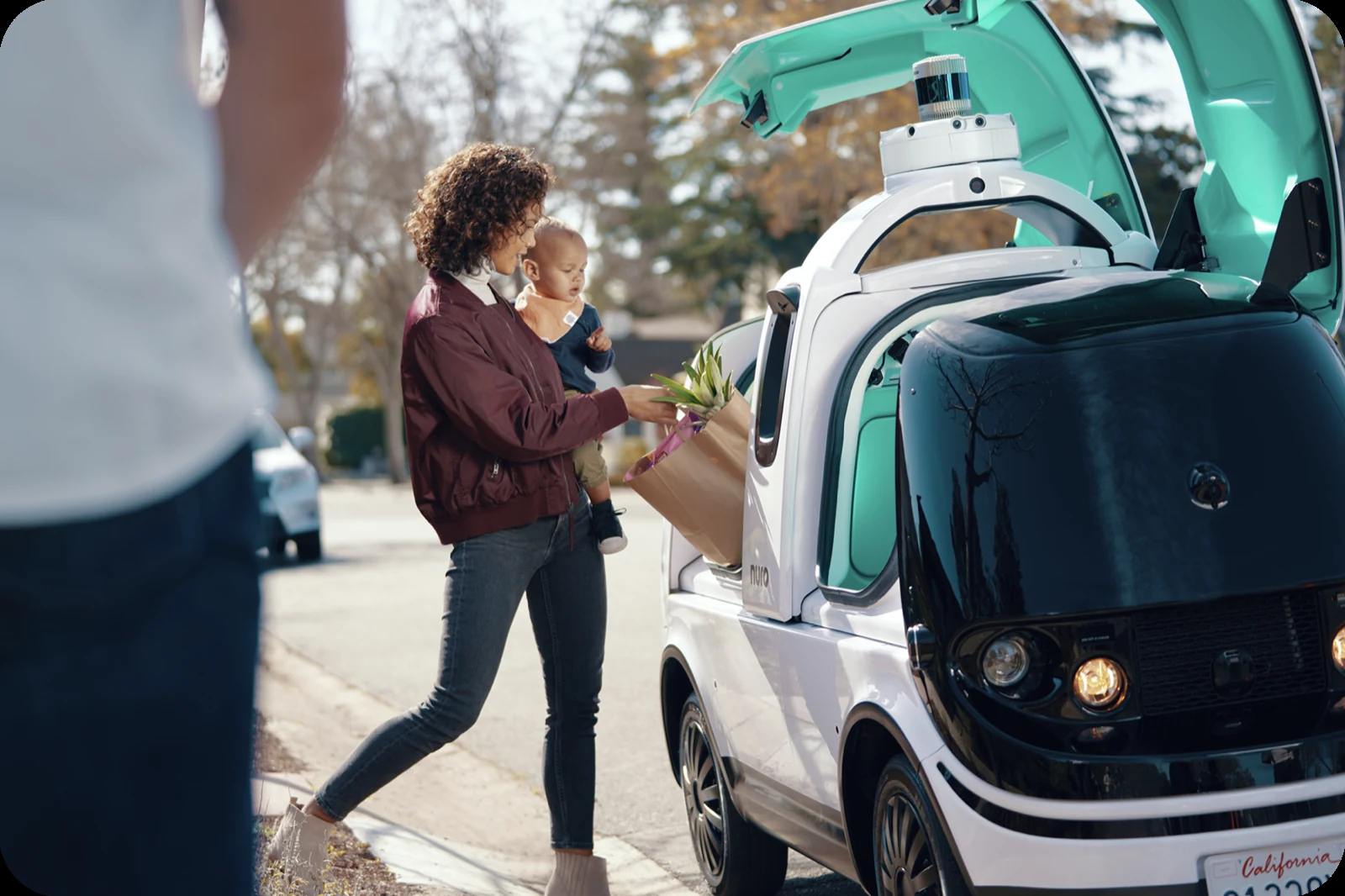 A Nuro autonomous delivery vehicle meeting a customer