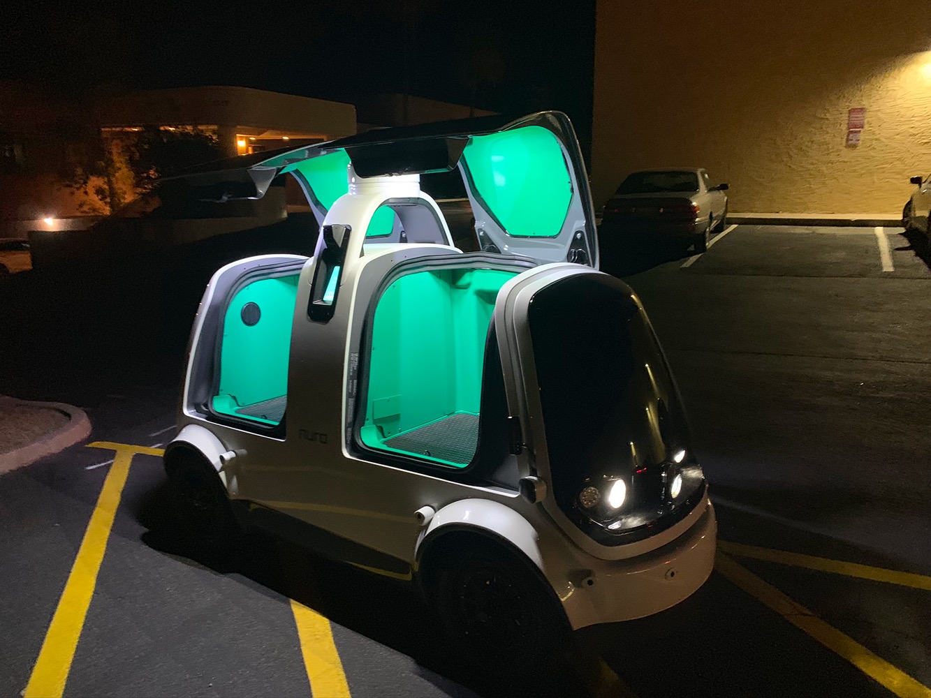 Nuro delivery vehicle at night with its illuminated compartments open during field research